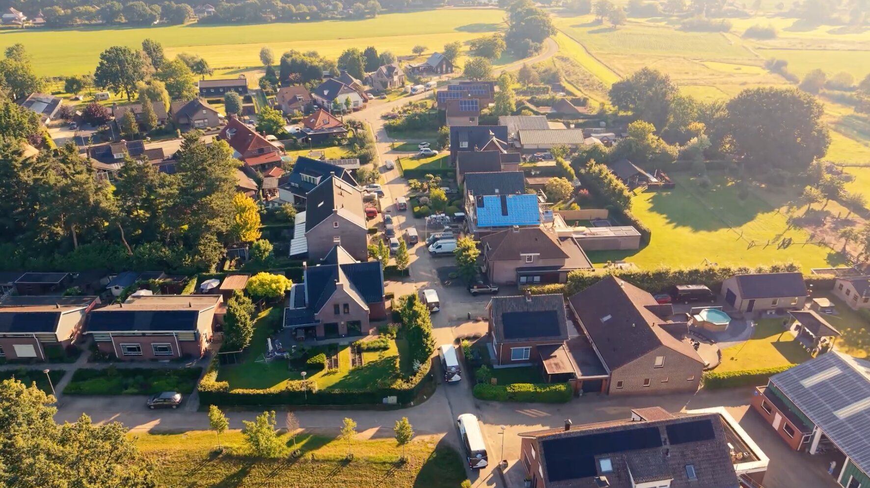 Luchtfoto van een dorp met woningen en weilanden in de omgeving